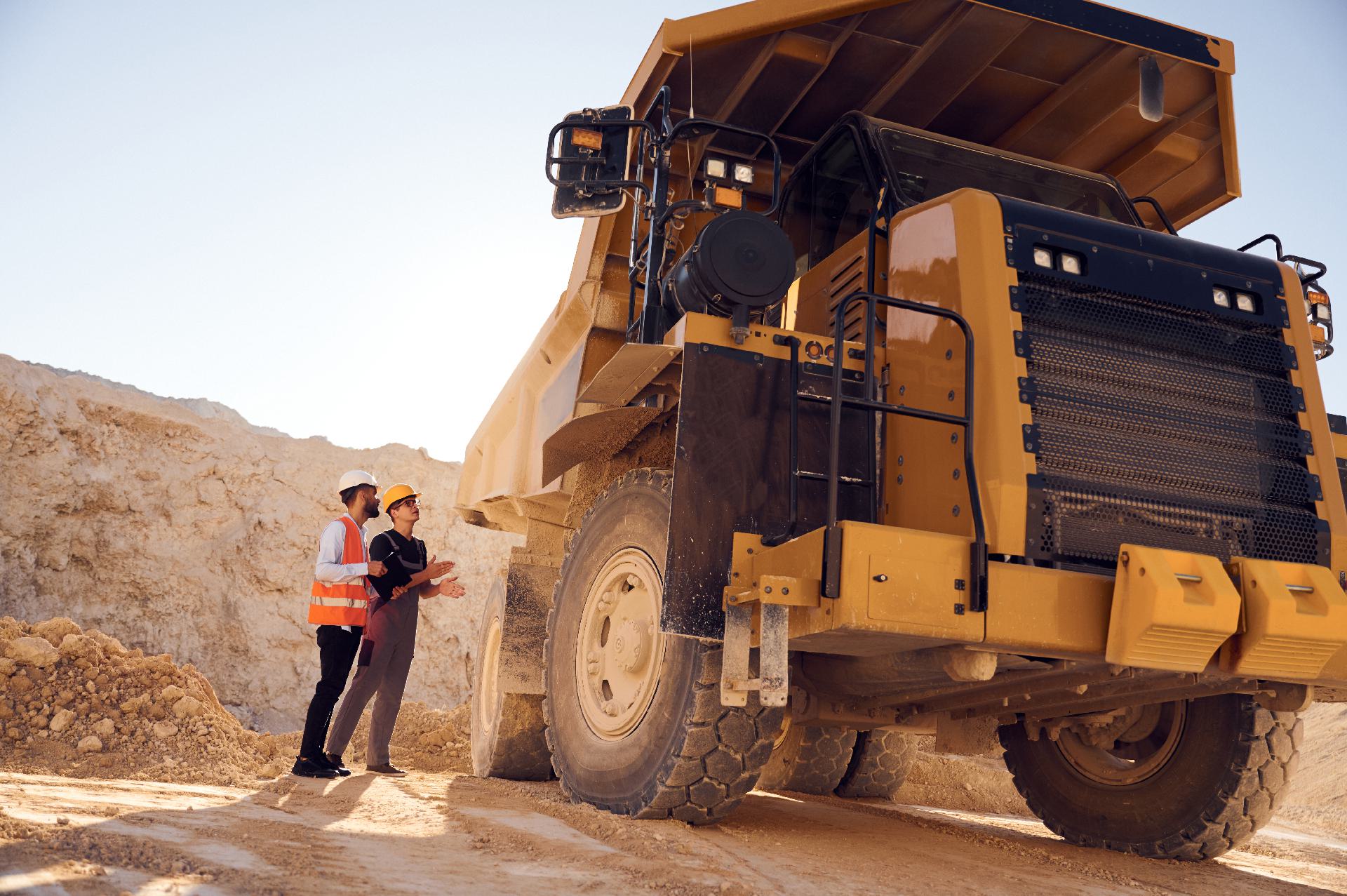 A field supervisor reviewing equipment condition data on a tablet at a remote mining site