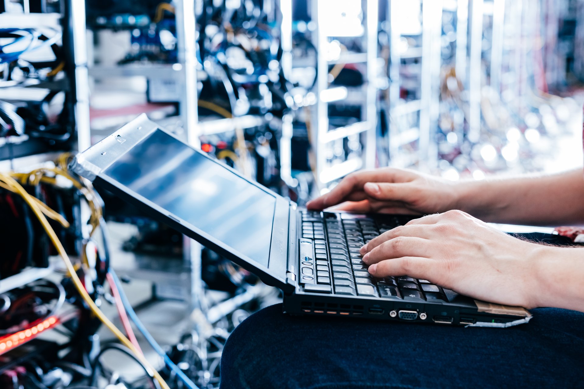 An IT specialist monitoring transaction and fraud dashboards on a computer, the operations view behind a real-time scoring pipeline