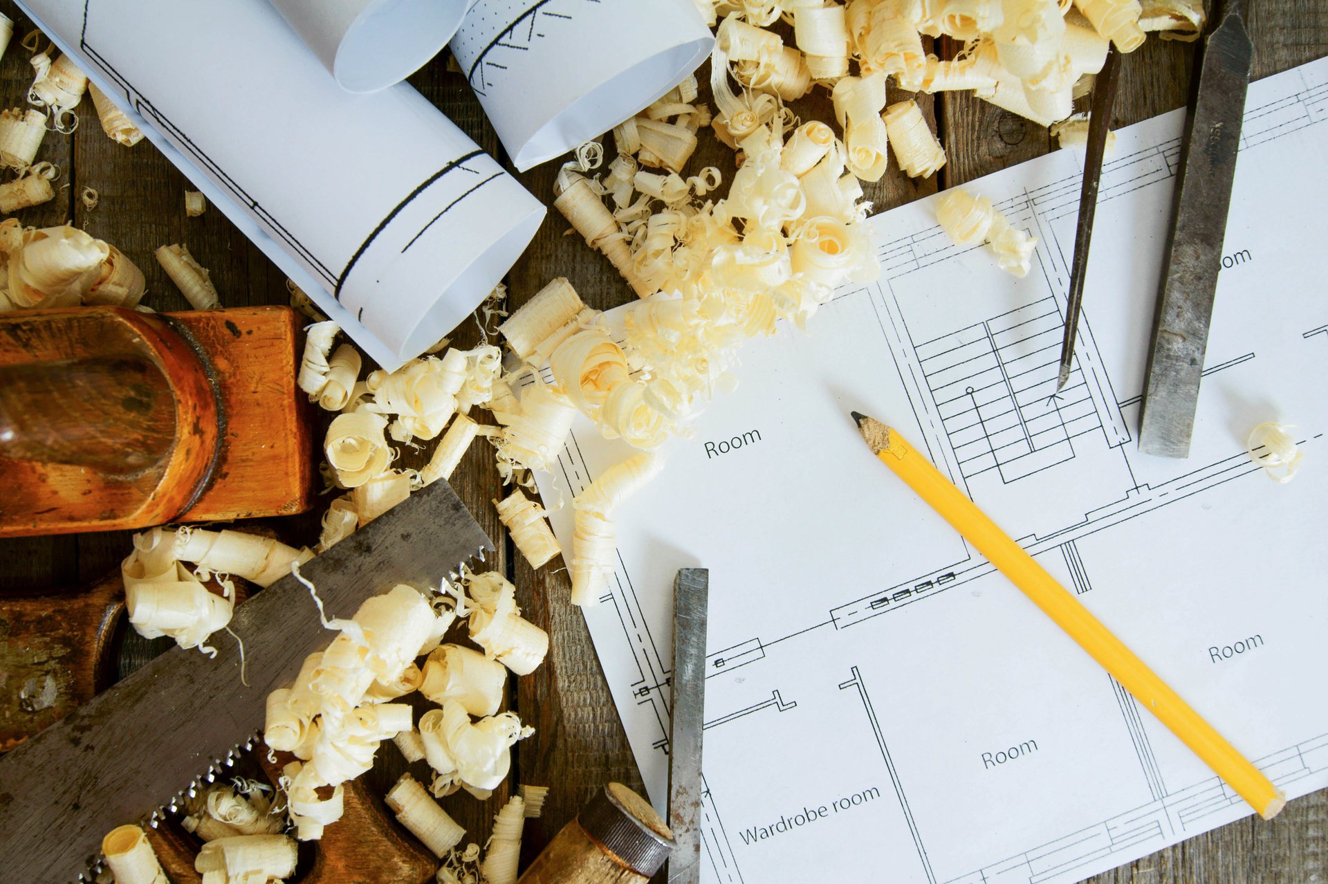Architectural and joinery building drawings and plans spread across a table, the source documents the approval agents read and cross-check