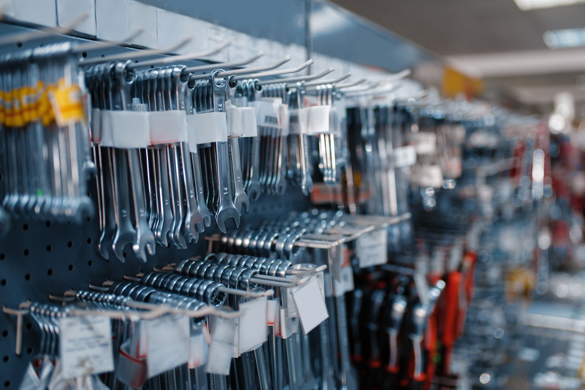 Wrenches arranged on racks in a tool store, representing the trades a maintenance request is routed to