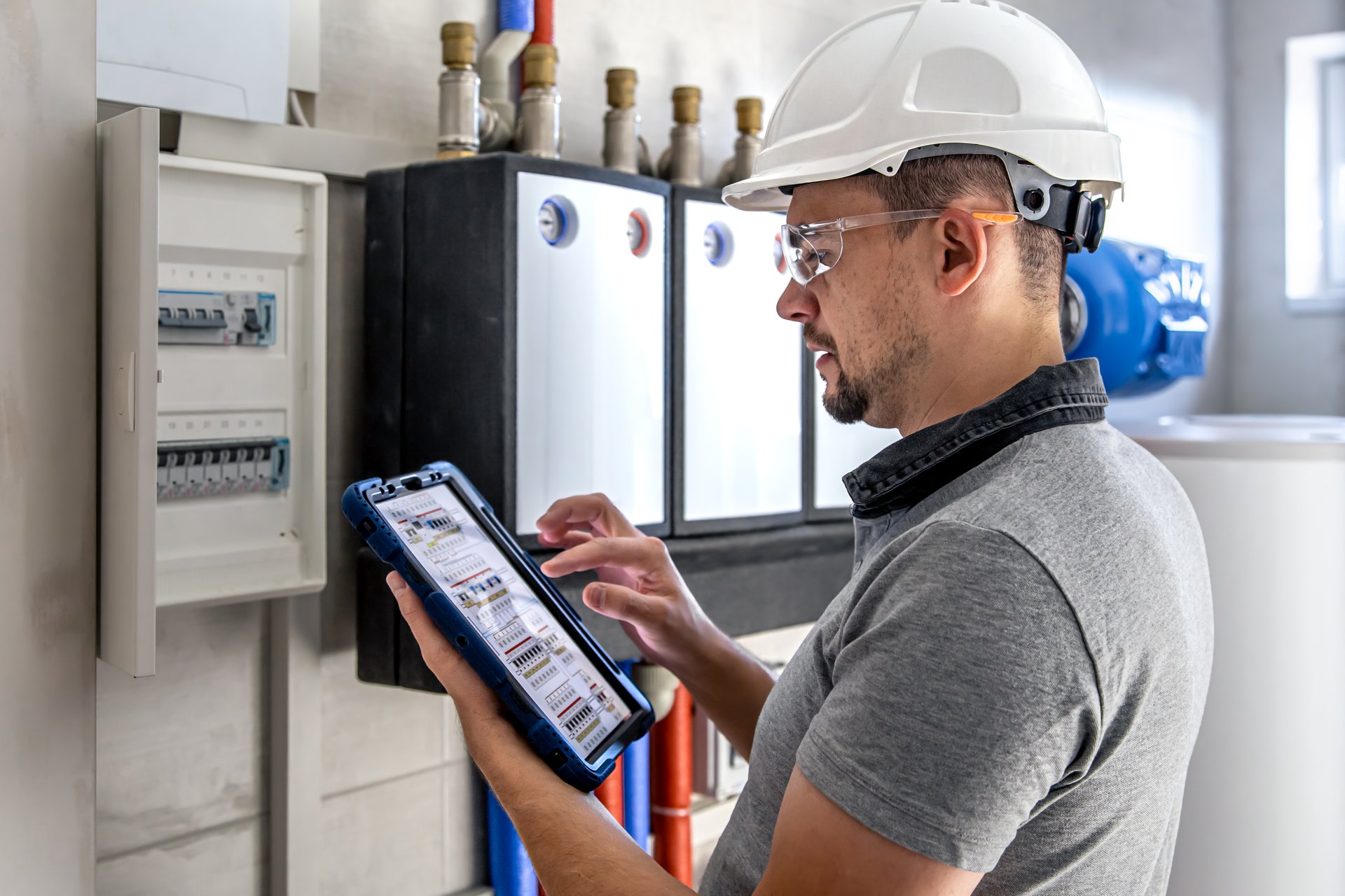 A utility technician working, focused, on an asset in the field, the inspections the offline Power Platform app captures