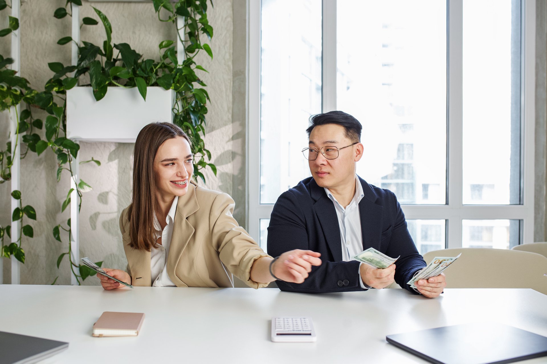 A man and a woman in an office reviewing payments and payout figures on screen, the money movement the marketplace runs on Stripe Connect each day