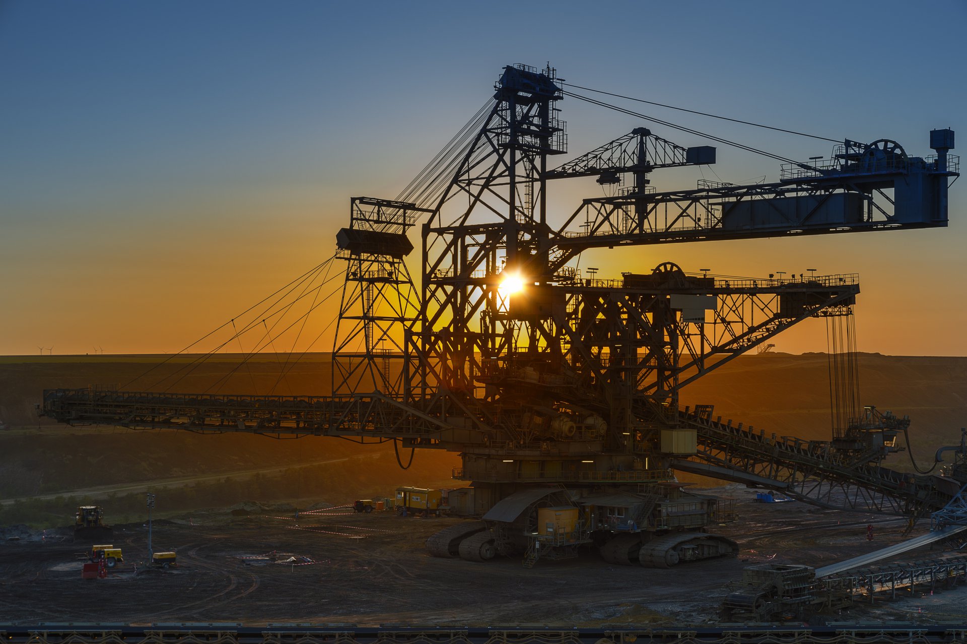 An open-cut mine landscape with benched pit walls and haul roads, the operation a Vertex AI haul-cycle forecast is trained on